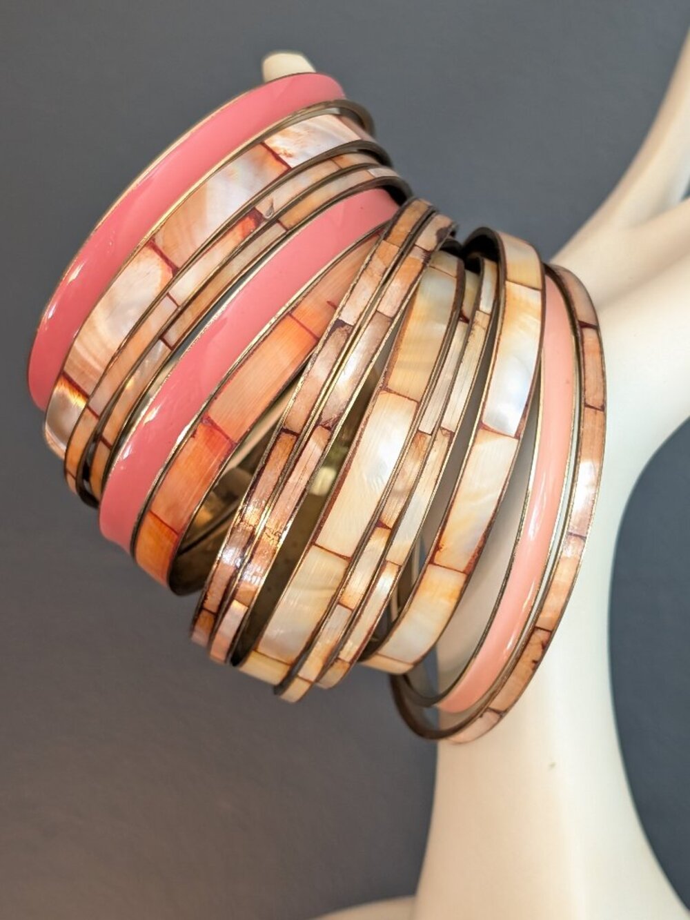 Bundle of orange toned paneled MOP bangles with coordinating enamel bangles